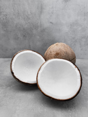 Fresh coconuts showing their white pulp on gray background. Copy space, bannerの写真素材