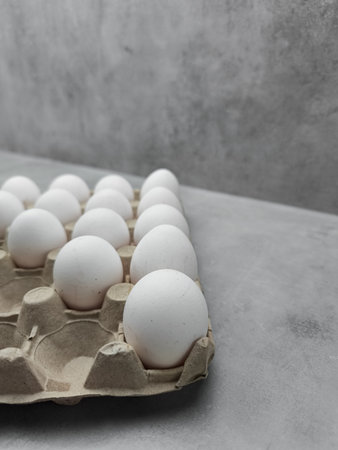 Carton of white eggs resting on gray surface easterの写真素材