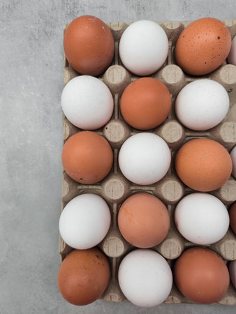 Fresh brown and white eggs forming a colorful pattern in carton