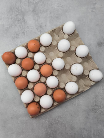 Fresh chicken eggs forming a checkerboard pattern on a cardboard tray