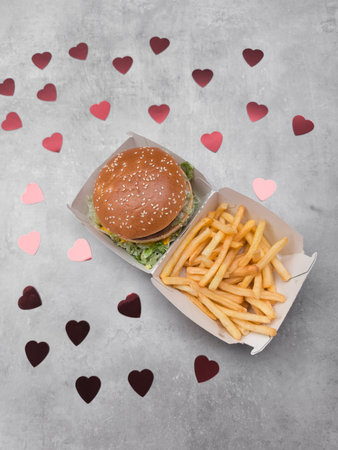 Burger and fries with valentines Mothers day hearts celebrating love and fast food galentinesの写真素材