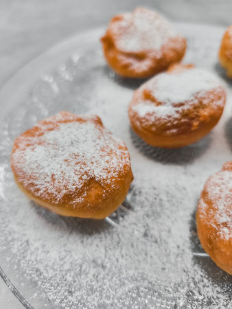 Delicious baursaki sprinkled with powdered sugar on glass plate in pragueの写真素材