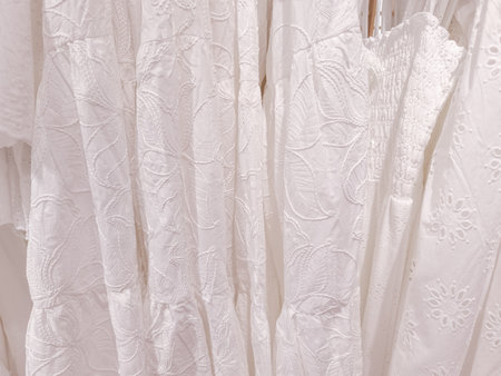 White embroidered dresses hanging in fashion store in prague