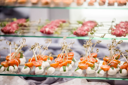 Catering preparing delicious cherry tomato and mozzarella skewers for wedding receptionの写真素材