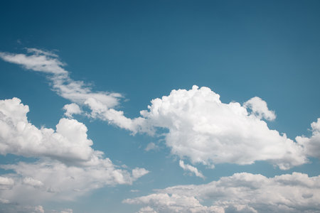 Bright blue sky with fluffy white clouds creating a peaceful atmosphere