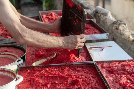 Villager making handmade tomato paste with angled shot under afternoon sun. Photo has taken in Izmir at Turkey.の写真素材