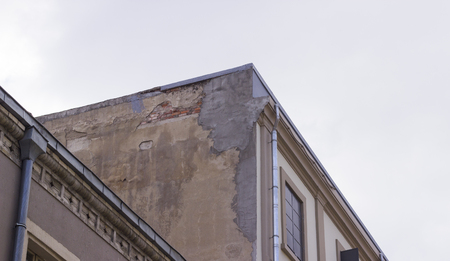 Corner shot of masonry old building under overcast sky backgroundの写真素材