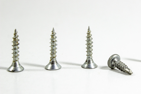 Cropped shoot of multiple screws on white blurry backgroundの写真素材
