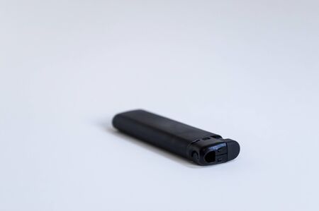 Perspective open shoot of horizontal black lighter on white surfaceの写真素材