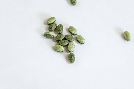 Clear top shoot of healthy green vitamin pills on white backgroundの写真素材
