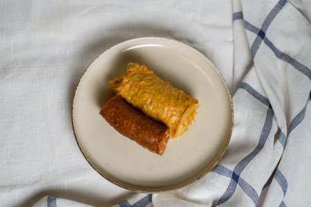 Stuffed cabbage rolls with meat and sausage on a plate.