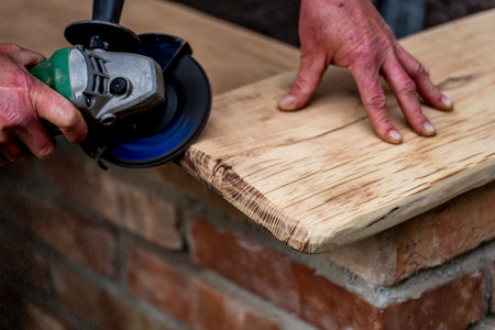 A carpenter is grinding a wooden part with an electric sander.の写真素材