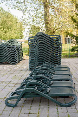 Stack of gray deck chairs. Stack of lounge chairs on the beach.の写真素材