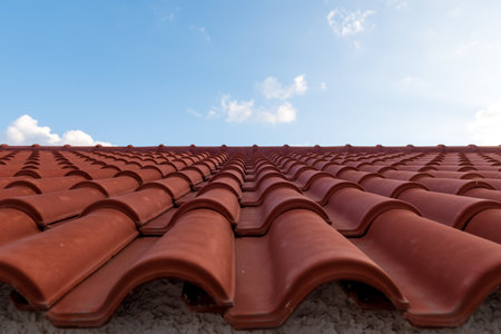 Red tile roof under blue sky. One side is a roof and the other is a pure blue sky.