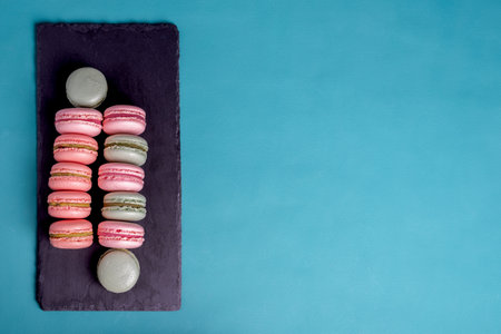 Close up colorful macarons dessert with vintage pastel tones on black board. .の写真素材