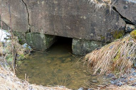Water flows from the fields into the brook in spring, snow melts.の写真素材