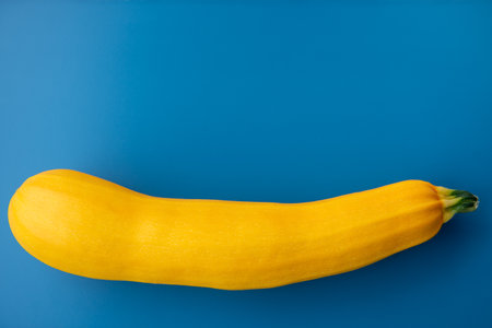 Yellow zucchini on the blue background. Vegetables from the garden.の写真素材