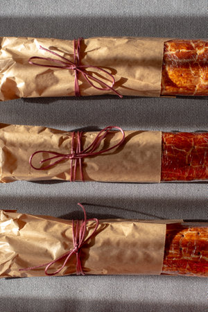 Traditional Hungarian Christmas cookies wrapped in craft paper, tied with ribbon on a gray textile background. Eco-friendly packaging. Zero wasteの写真素材