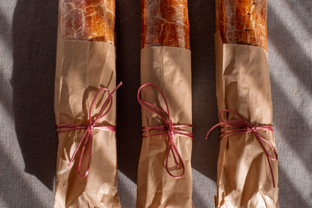 Traditional Hungarian Christmas cookies wrapped in craft paper, tied with ribbon on a gray textile background. Eco-friendly packaging. Zero wasteの写真素材