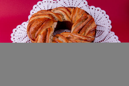 Swedish cake with cardamom. Kanelbulle, Swedish homemade cake on red background. Selective focus