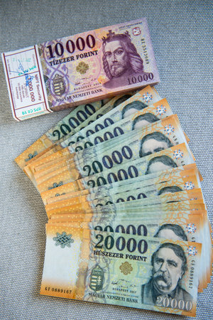 Hungarian forint, mixed 10,000 and 20,000 HUF banknotes on gray background.