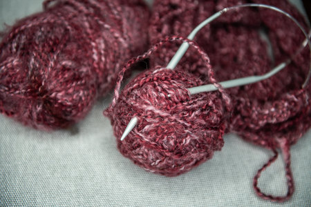 yarns, knitting needles and pattern sample on gray background. closeup
