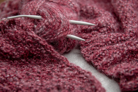 yarns, knitting needles and pattern sample on gray background. closeup