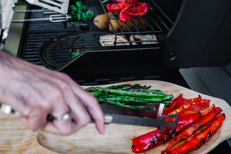 Delicious grilled vegetables asparagus, paprika on barbecue grill with smoke and flame. Asparagus and red pepper on the wooden plate.の写真素材