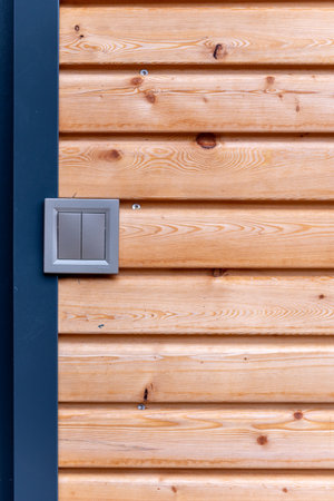 modern gray double light switch on the wall of wooden houseの写真素材