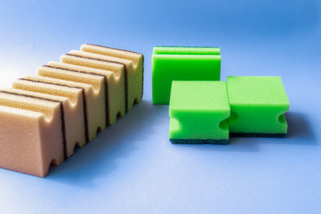 sponges on a blue background. eco-friendly sponges in natural tones on a blue background. Minimalist composition for sustainable household or cleaning themes.の写真素材