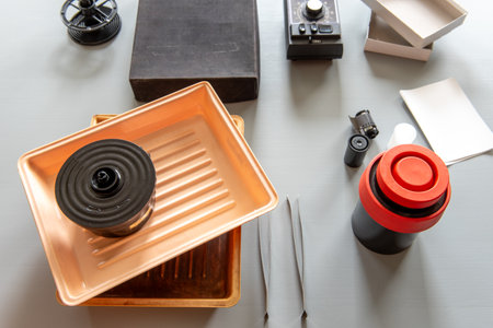 Analog photography tools including trays, film reels, a developing tank, and accessories used in traditional darkroom photo development.の写真素材