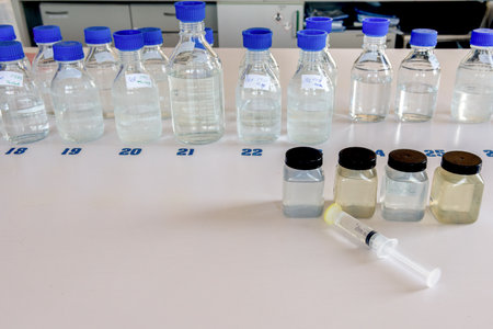 Laboratory equipment. Laboratory storage bottles with blue polypropylene cap and plastic bottles on white table.の写真素材