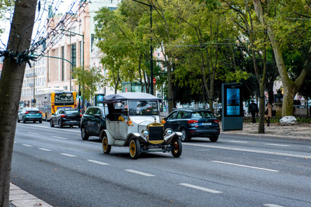 old retro vintage car on a tree-lined street in Lisbon, Portugal, surrounded by historic buildings and urban scenery.のeditorial素材
