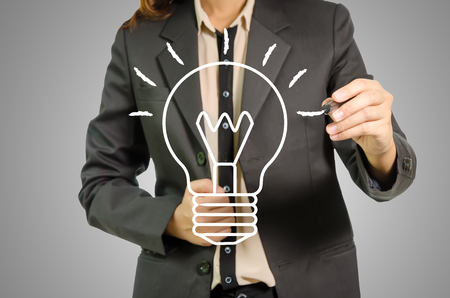 Business woman with idea light bulb on gray Background.の写真素材