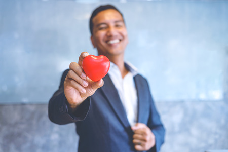 Red heart in hand for business man.eamwork successful Meeting Workplace strategy Concept.の写真素材