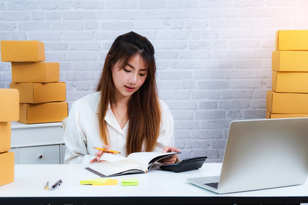 Woman small business owner working at home with packing box on workplace. online shopping SME entrepreneur or freelance working concept.の写真素材