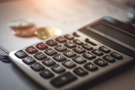 Accounting cryptocurrencies investors of bitcoins with documents and calculator in background.の写真素材