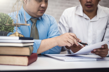 Two male lawyer discussing with contract papers and wooden gavel on tabel in courtroom. justice and law ,attorney, court judge, conceptの写真素材