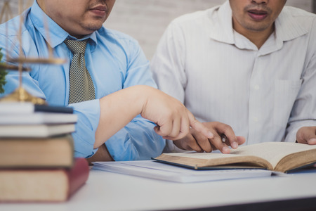 Male lawyer teaching new lawyer and  discussing with contract papers and wooden gavel on tabel in courtroom. justice and law ,attorney, court judge, concept.の写真素材