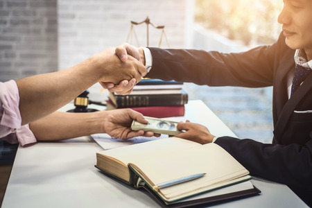 Male lawyer man and businessman shaking hands over table after discussing a contract agreement. justice and law ,attorney, court judge, concept.の写真素材