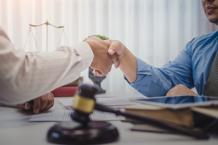 Businessman shaking hands with lawyers after discussing a contract agreement in office. justice and...