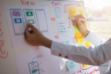 Closeup hand of designer woman sort layout of drawing application for developing for mobile applications. User experience Design concept.の写真素材