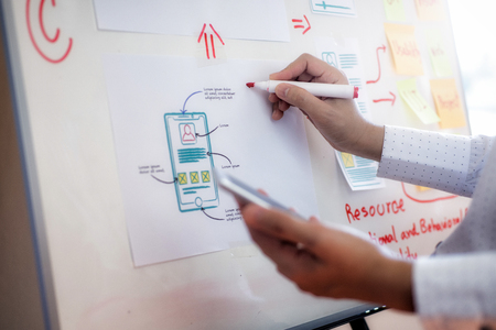 Closeup hand of designer woman sort layout of drawing application for developing for mobile applications. User experience Design concept.の写真素材
