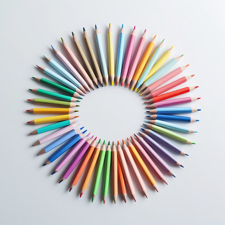A vibrant collection of colored pencils is arranged in a perfect circle, viewed from directly above on a clean white background. The pencils showcase a wide spectrum of colors, with their sharpened tips pointing inwards towards the center of the circle. This overhead flat lay composition highlights the diversity of hues and the organized arrangement of the art supplies.の素材