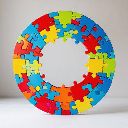 A circular jigsaw puzzle composed of brightly colored pieces forms the letter 'O'. The puzzle is arranged on a clean white surface with a neutral gray background. The vibrant colors of the puzzle pieces include red, blue, yellow, green, orange, and pink, creating a visually appealing and playful design. The interlocking nature of the puzzle pieces is clearly visible.の素材