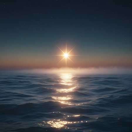 A brilliant starburst sun hangs low on the horizon, casting a shimmering golden reflection across the calm surface of the ocean. The sky transitions from deep blue at the top to a soft, warm glow near the horizon, where a gentle mist or fog hovers. The water is a deep blue, with gentle ripples catching the light, creating a path of shimmering gold. The scene is serene and peaceful, evoking a sense of wonder and tranquility.の素材