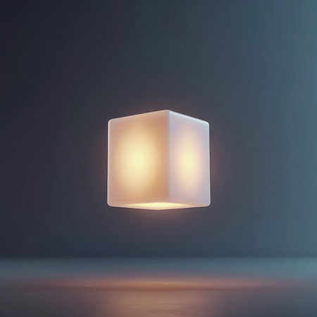 A frosted white cube is presented against a dark, moody background. The cube contains a soft, internal light source that illuminates its surfaces, with two distinct bright spots visible. A subtle reflection of the light is cast on the surface below.の素材