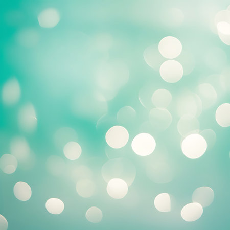 A soft and dreamy abstract background featuring numerous out-of-focus circles of light, known as bokeh, against a gradient of teal and light turquoise. The circular lights vary in size and intensity, with some appearing brighter and more defined, creating a gentle, luminous effect. The overall impression is one of tranquility and subtle sparkle, suitable for various decorative or conceptual uses.の素材