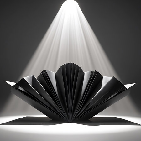 A black, accordion-folded paper sculpture is dramatically lit from above by a bright spotlight. The sculpture is shaped like an open fan or a book with many pages, casting a sharp shadow on the illuminated surface beneath it. The contrast between the dark object and the bright light creates a striking visual.の素材