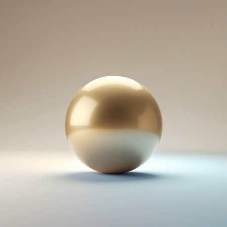 A single, perfectly round, polished golden sphere rests on a light-colored surface. The sphere exhibits a smooth, reflective finish with a subtle gradient where the top half appears more golden and the bottom half transitions to a lighter, almost cream color. Soft studio lighting creates gentle highlights and shadows, emphasizing its smooth, three-dimensional form against a neutral, softly lit background.の素材